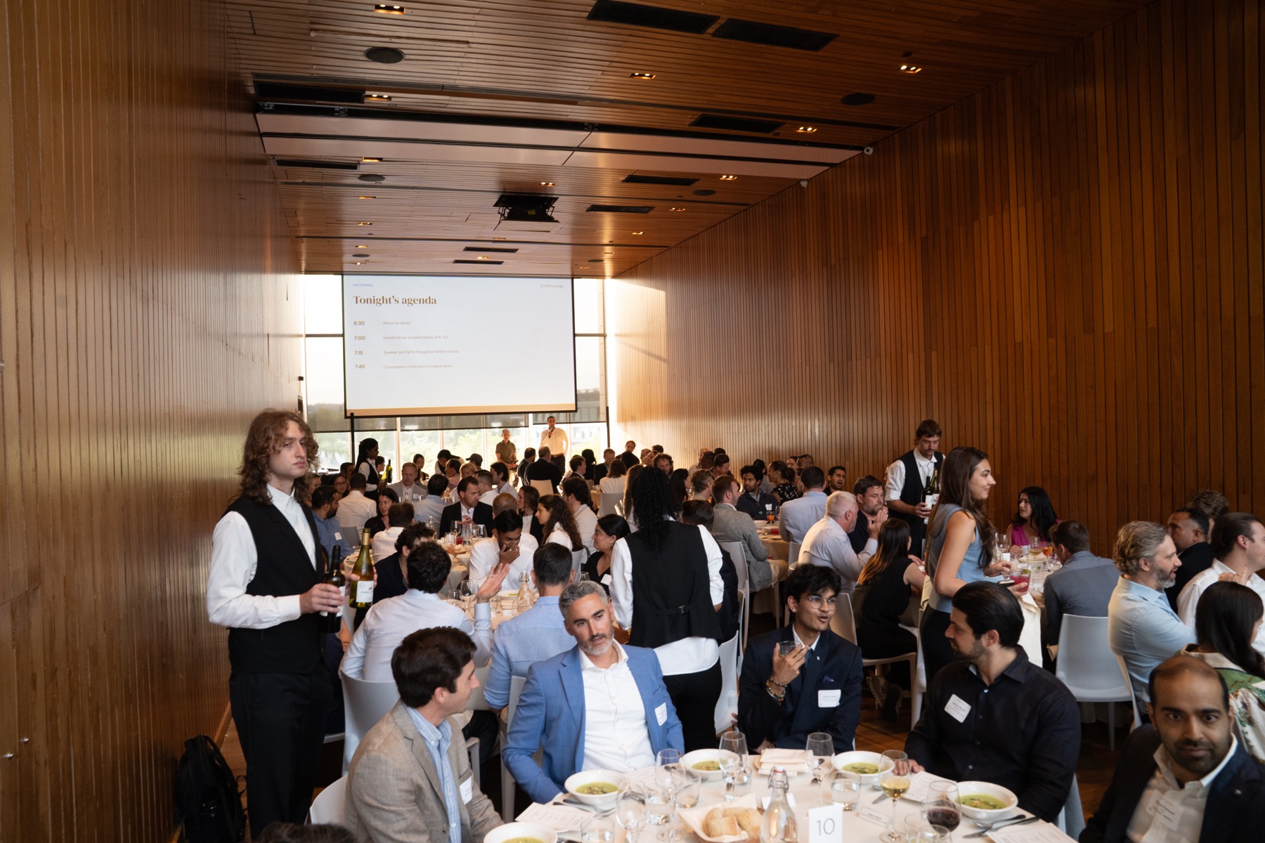 Wide room view of a seated event dinner